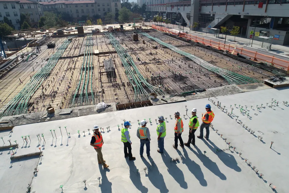 Workers in hard hats and high-visibility clothing on a construction site.