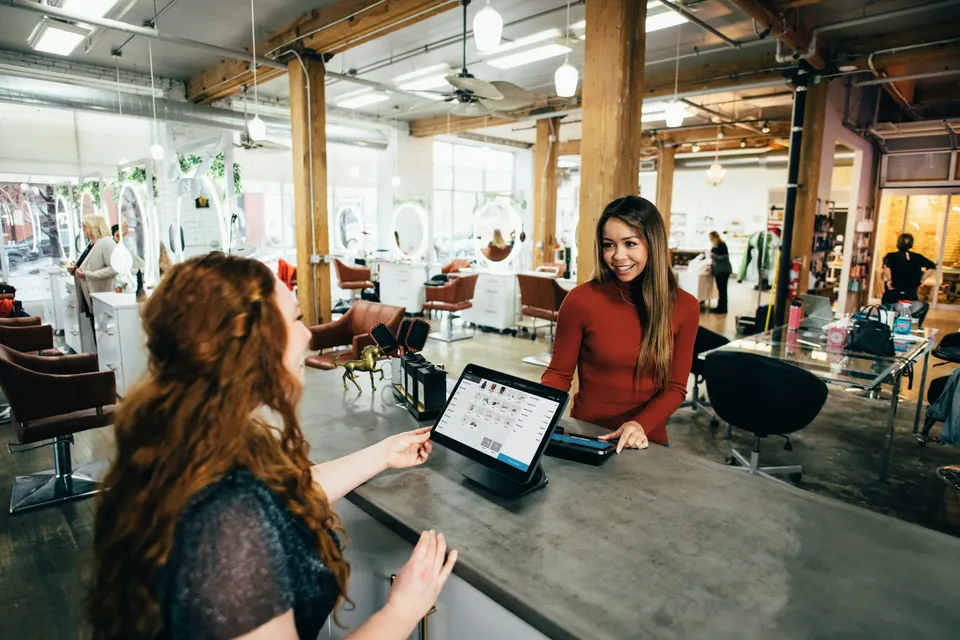 A customer and shop attendant at a payment counter.